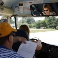 Program Consultant John Wyatt monitors Amber Brown as she navigates the course during the driver trainer instructor training at Franklin County High School. Brown has been driving a bus for three years after her aunt, a bus driver in Boone County, encouraged her to give it a try. 
Photo by Amy Wallot, July 9, 2014